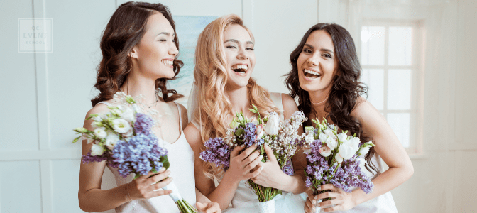 bride with bridesmaids laughing and holding bouquets