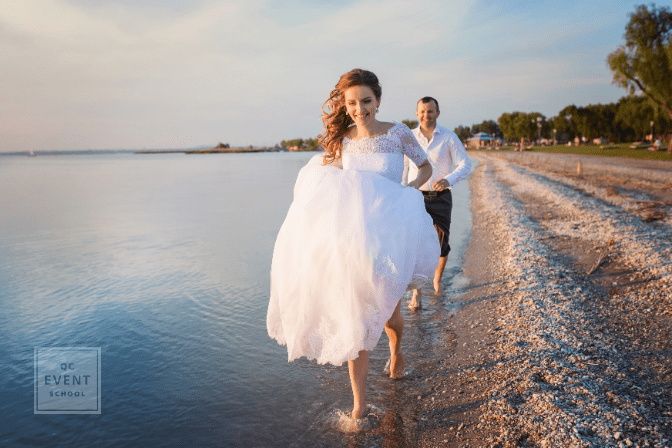 bride and groom running through water