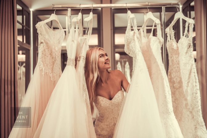 Attractive young bride is smiling while choosing wedding dress in modern wedding salon