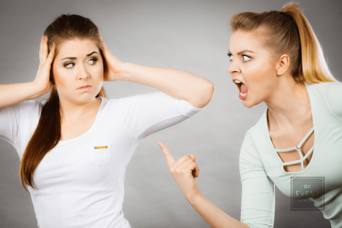 woman holding hands over ears as another woman shouts at her
