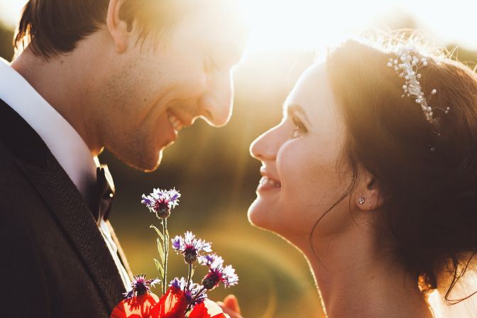 Sunshine portrait of happy bride and groom outdoor in nature location at sunset. Warm summertime. Wedding planning business.