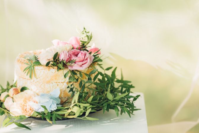 Beautiful wedding cake decorated with fresh flowers. Wedding planner salary article.