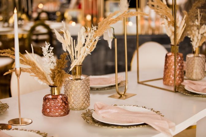 Table setting at a luxury wedding and Beautiful flowers on the table. wedding decor, flowers, pink and gold decor, candles. Festive table decor. Party planning business article.
