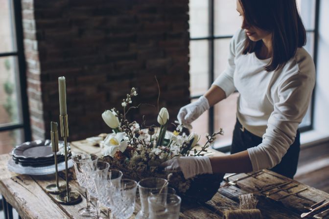Table setting. A woman decorates the table for the holiday. High quality photo. Party planning business article.